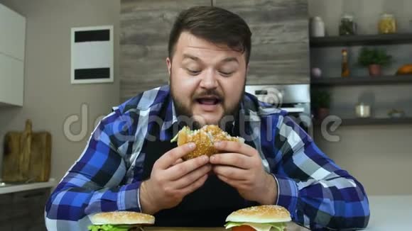 一个留胡子的胖子咬了一块汉堡包食物很好吃胖子很高兴不健康的视频的预览图