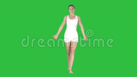 女人在绿色屏幕上行走时做早晨伸展运动Chroma键视频的预览图