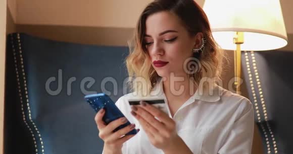 女人把信用卡号码写在智能手机上视频的预览图
