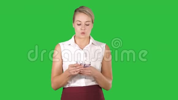 快乐的年轻女商人在绿色屏幕上手持欧元纸币的扇子铬钥匙视频的预览图