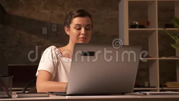 可爱的白种人女商人坐在她的电脑前微笑着感激地从其他工人那里拿走文件视频的预览图