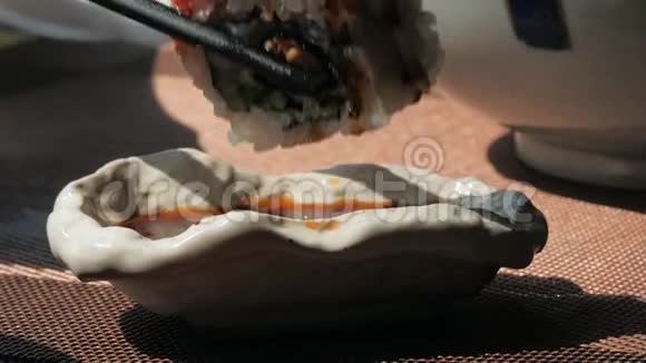 把面包卷蘸到酱油里的特写镜头用筷子把面包卷蘸上酱油日本菜视频的预览图