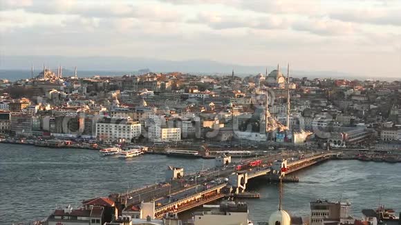 日落时欣赏加拉塔大桥和清真寺许多海鸥在飞翔旅游船在漂浮伊斯坦布尔视频的预览图