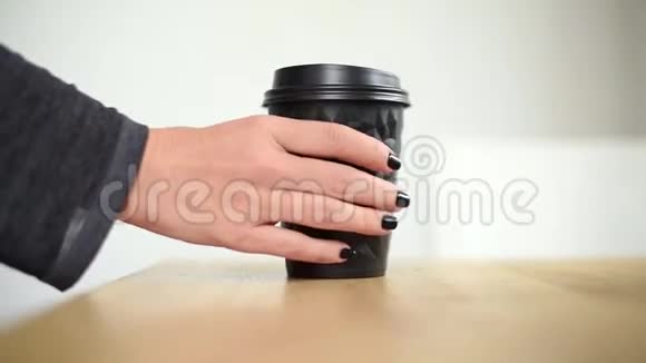 特写女性取一杯咖啡或茶放回去专注于纸杯手拿纸杯咖啡热的视频的预览图