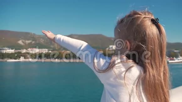 可爱的女孩高兴地举起手欢迎大海视频的预览图