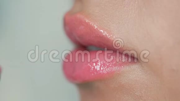 特写女人嘴唇涂上淡淡的油彩慢动作视频的预览图