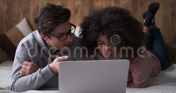 在床上用笔记本电脑放松的情侣视频的预览图
