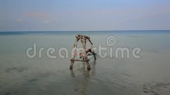 女孩在海中荡秋千水荡秋千失乐园无人居住的岛屿跳进水里视频的预览图