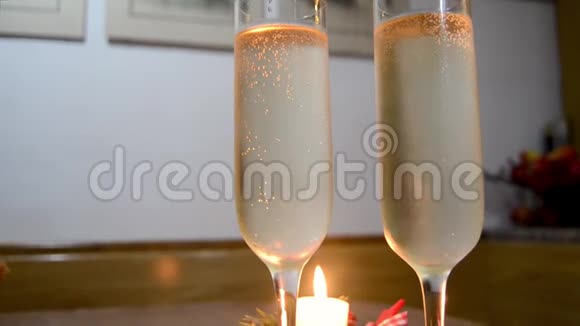 木桌上放着香槟的酒杯和烛光视频的预览图