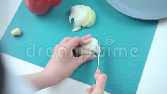 女人从后面切洋葱在切割板上视频的预览图