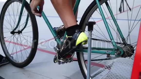 Cyclist将脚踏车和脚趾夹绑在velodrome轨道自行车门上的老式轨道自行车上视频的预览图