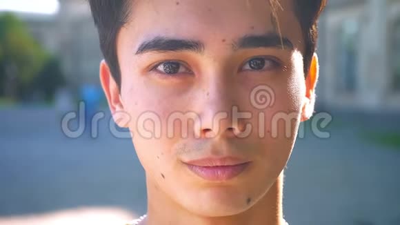 可爱的亚洲男人特写镜头戴着牙套微笑看着镜头放松寒冷的心情外面阳光明媚视频的预览图