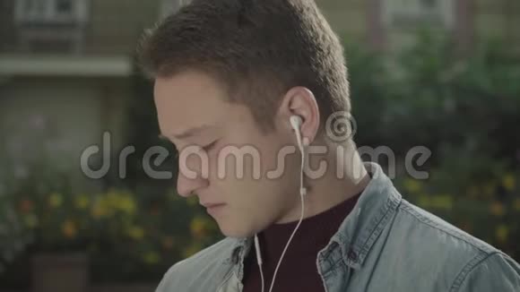 戴耳机的年轻人嚼着口香糖把脸贴紧视频的预览图