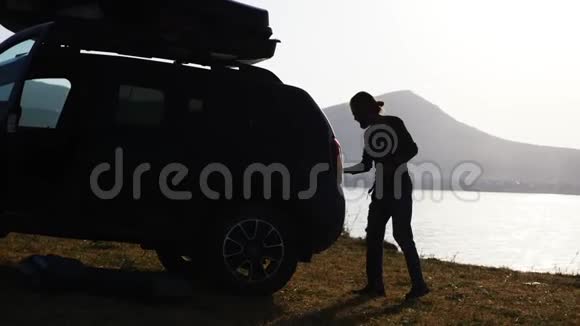 一个留胡子的年轻人从营地的车里拿出一个野营装备视频的预览图