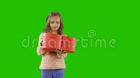 孩子们礼物中的喜悦小女孩拿着一个心形的盒子打开它并真诚地微笑着视频的预览图