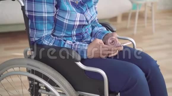 残疾非裔美国妇女坐轮椅使用智能手机视频的预览图