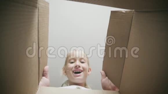 惊讶的女孩打开纸箱打开纸箱看里面儿童情感概念视频的预览图