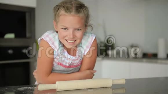 小可爱的女孩在厨房做饭在做蛋糕和饼干的时候玩得开心微笑和看着相机视频的预览图