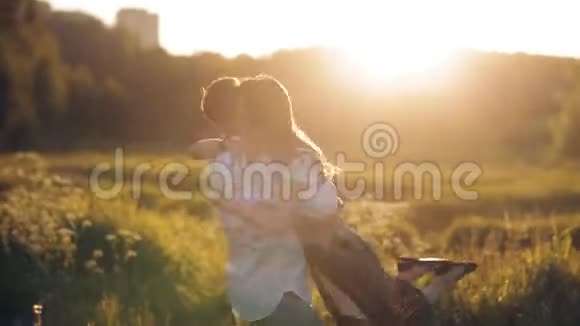 夏天日落时分年轻的男女在草地上漫步浪漫夏日的爱情相聚欢乐浪漫的回忆视频的预览图