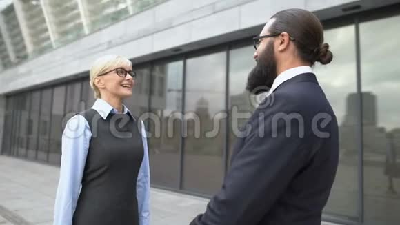 男女同事在街上握手商务合作会议视频的预览图