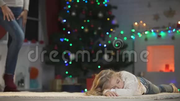 小女孩睡在圣诞树下妈妈过来拥抱她童年视频的预览图