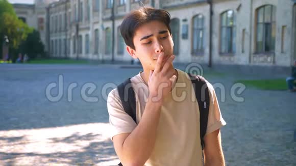 可爱的亚洲男人用手指在嘴唇上思考上下打量视频的预览图