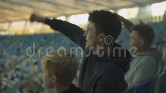 男球迷和孩子挥舞双手支持足球队庆祝进球视频的预览图