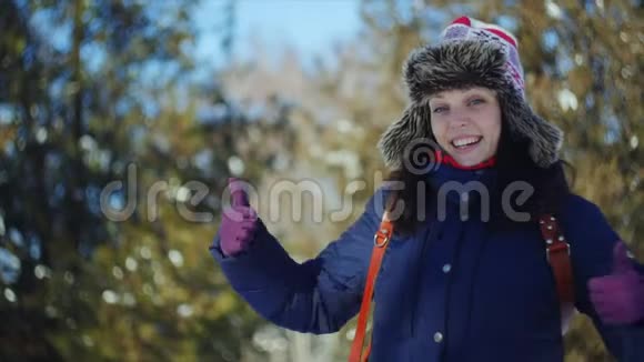 4K近距离拍摄了一个快乐的女人在冬季公园散步她用双手愉快地做手势视频的预览图