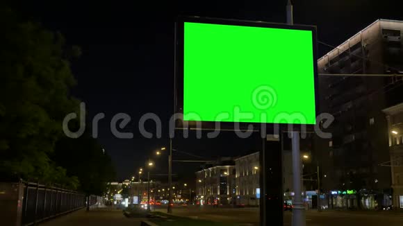 晚上广告牌在马路旁与城市建筑对峙视频的预览图