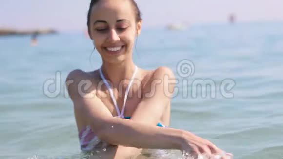 快乐快乐快乐年轻美丽的女孩在夏天在海里游泳和飞溅视频的预览图