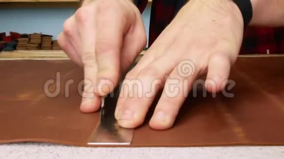 工匠用办公刀切割一张真皮手工制造的关门视频的预览图