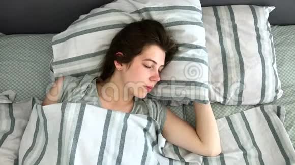 美丽的年轻的布鲁内特在她的床上睡在清晨甜蜜温馨的少女观视频的预览图