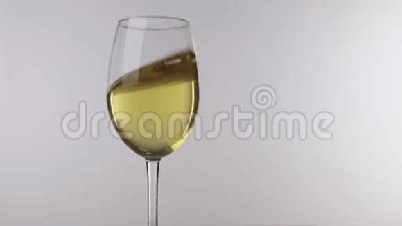 运动的白酒在酒杯中站在白色的背景上特写视频的预览图