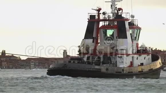 一辆载着缆绳的船式拖拉机在威尼斯河上漂浮视频的预览图
