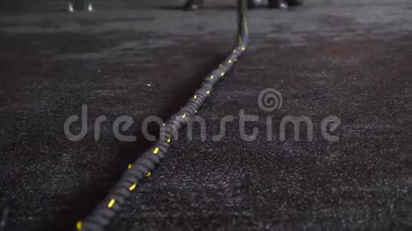 在橡胶地板上的健身健身馆里把交叉黑色绳子训练起来视频的预览图