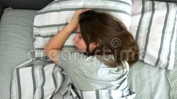 美丽的年轻的布鲁内特在她的床上睡在清晨甜蜜温馨的少女观视频的预览图