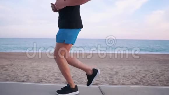 一个人在海滩上跑步的运动员视频的预览图