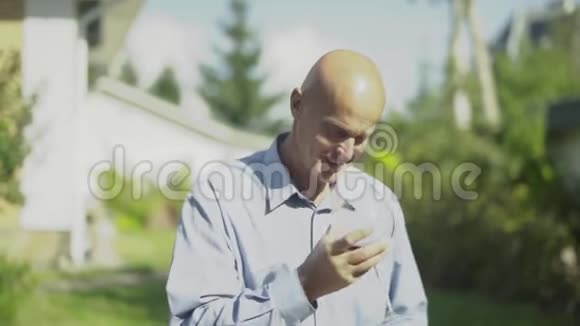 成熟的秃头男人在户外喝着一杯酒视频的预览图