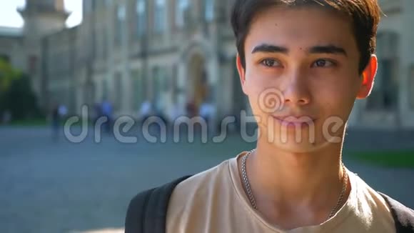 亚洲男人漂亮的脸在慢镜头下看镜头后面有城市景色视频的预览图