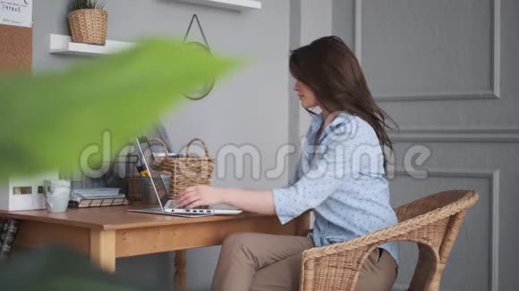 自由职业者在家工作有魅力的女孩在家里用笔记本电脑工作视频的预览图