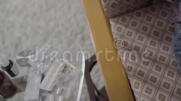 药片药桌子上的糖浆和带狗玩具的摇椅上的孩子视频的预览图