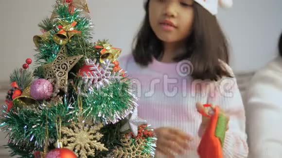 亚洲小女孩装饰圣诞树祈祷最美好的事视频的预览图