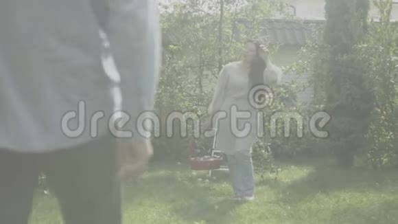 成熟的女人带着篮子去花园里的丈夫那里视频的预览图