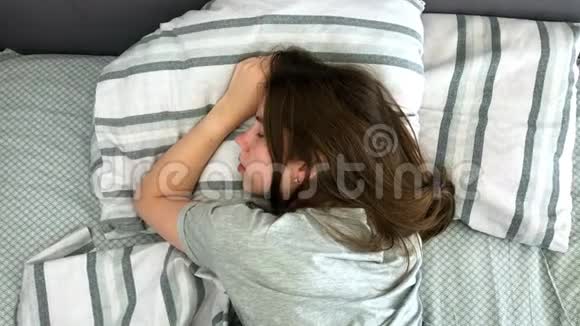 清晨美丽的黑发少女迷人地睡在床上甜美温馨的少女视野视频的预览图