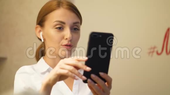 年轻女性使用智能手机和耳杆进行视频通话的肖像视频的预览图