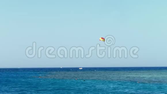 风筝上的降落伞在水面上盘旋靠在晴朗的蓝天上夏天海景水面视频的预览图