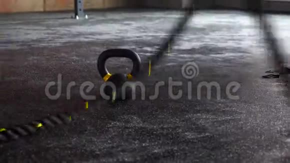 在橡胶地板上的健身健身馆里把交叉黑色绳子训练起来视频的预览图