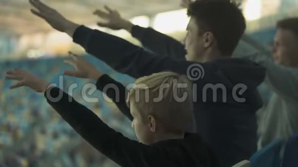 男球迷和男孩子们在运动场上为足球队加油视频的预览图