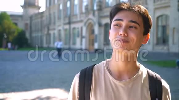 快乐的亚洲男孩男人戴着牙套微笑站在空荡荡的街道城市阳光视频的预览图