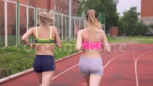 两个年轻的运动女孩跑到终点线举起双手欢呼视频的预览图